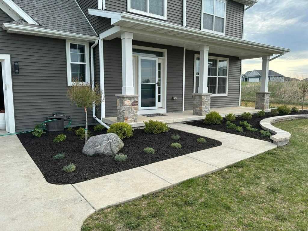 Mixed perennial and shrub planting bed with Zone 5b hardy plants in bloom on a residential property in Sheboygan County, Wisconsin