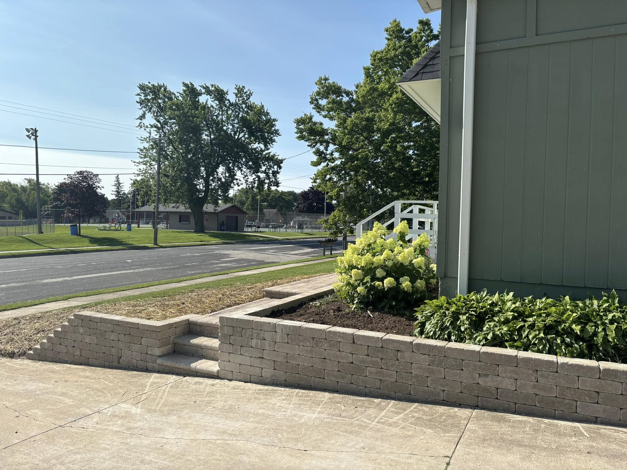 Completed retaining wall and landscape installation by a professional landscaping crew in Sheboygan County, Wisconsin