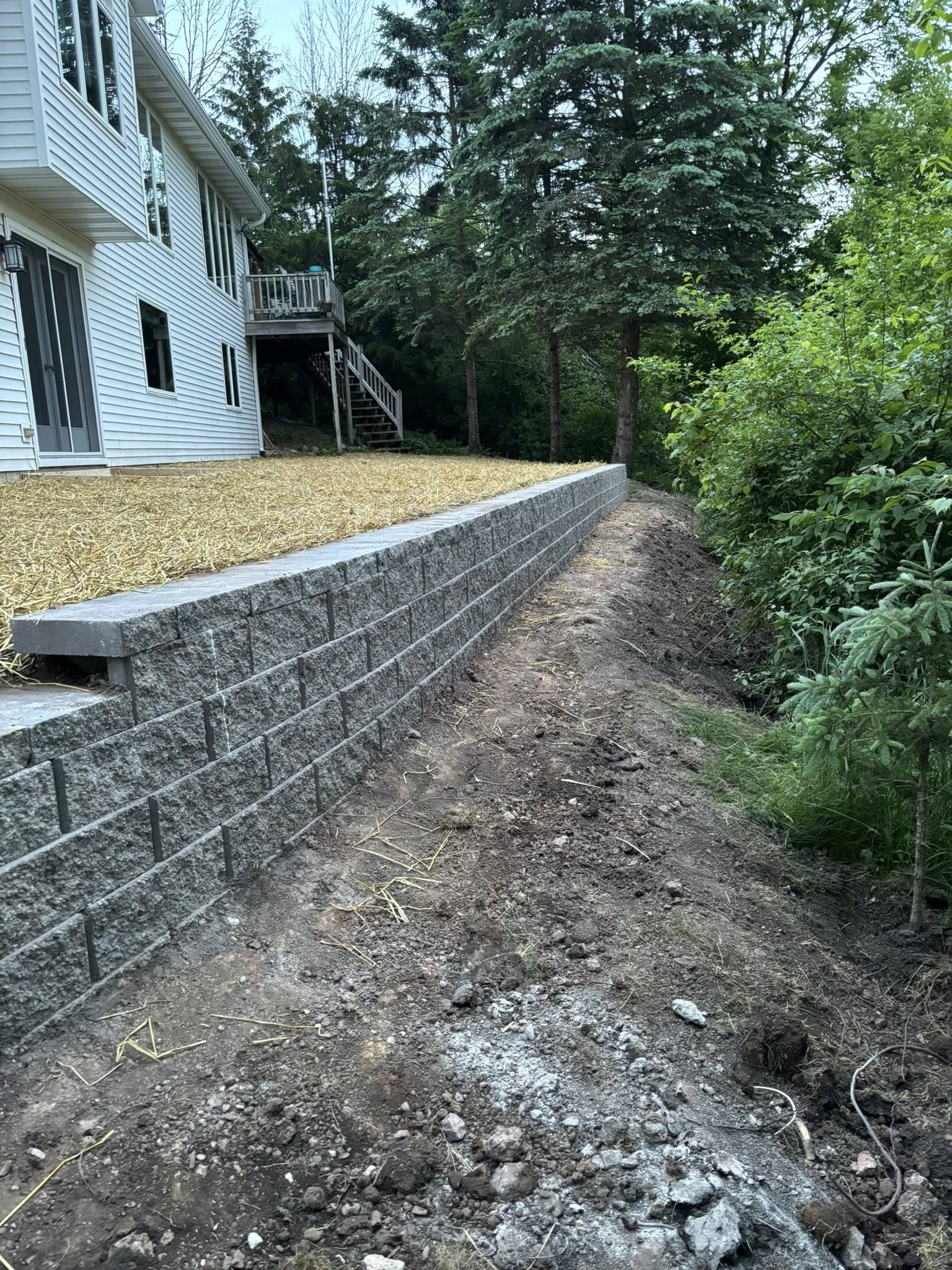 Terraced retaining walls and planted tiers turning a sloped backyard into usable space in Sheboygan County, Wisconsin